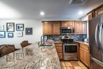kitchen with granite counters, stainless steel appliances, decorative tile back splash